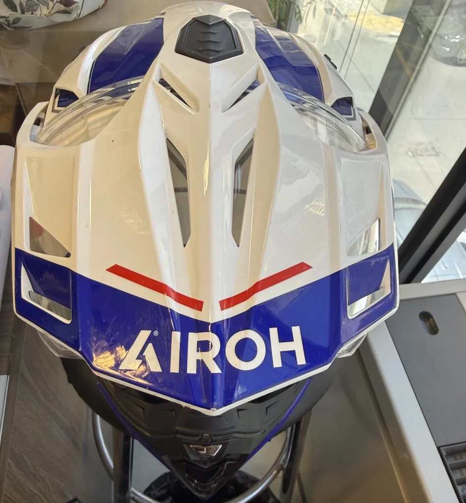 Πάνω όψη του κράνους Airoh Commander 2 Reveal Blue Red Gloss, με εμφανές το γείσο, τους αεραγωγούς στο επάνω μέρος και τα μπλε-κόκκινα γραφικά.