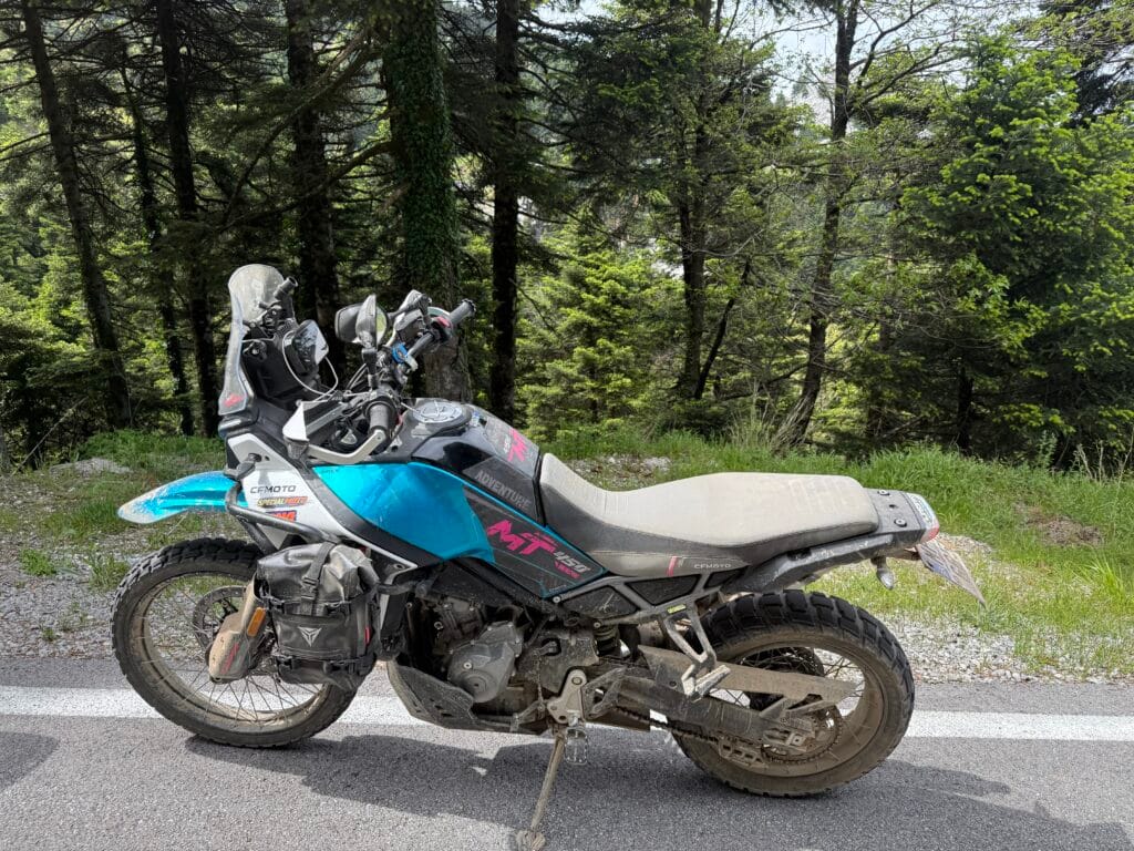 Λερωμένη μοτοσυκλέτα CFMOTO 450MT σταθμευμένη στην άκρη του δρόμου, μετά από off‑road διαδρομή σε δασική περιοχή της Εύβοιας.