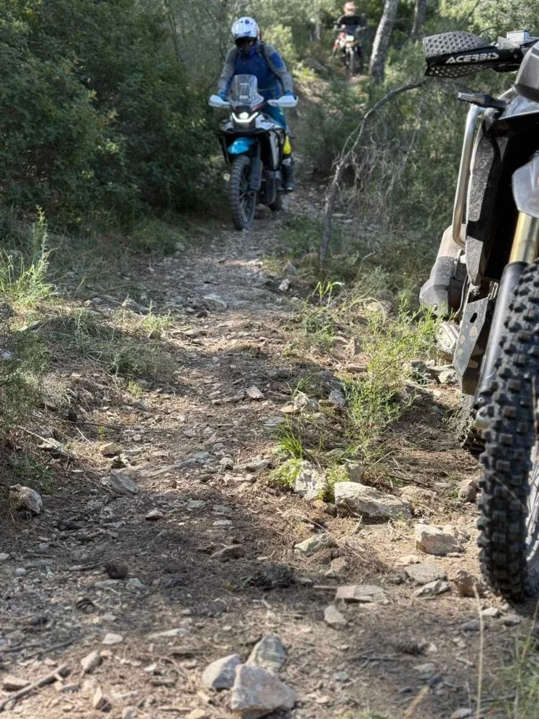 adventure μοτοσυκλέτα σε τεχνικό χωμάτινο μονοπάτι με πέτρες