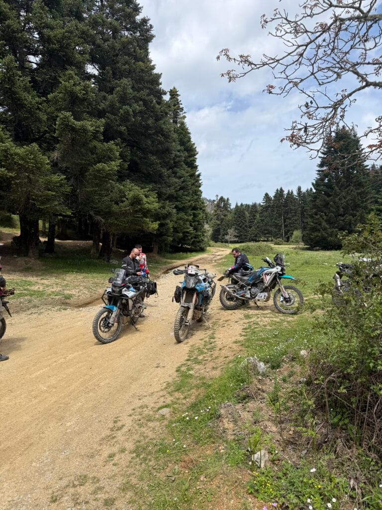 Ομάδα μοτοσυκλετών CFMOTO 450MT σταματημένες σε χωμάτινο δρόμο κοντά στο καταφύγιο Δίρφυς στην Εύβοια, μέσα σε πευκοδάσος.