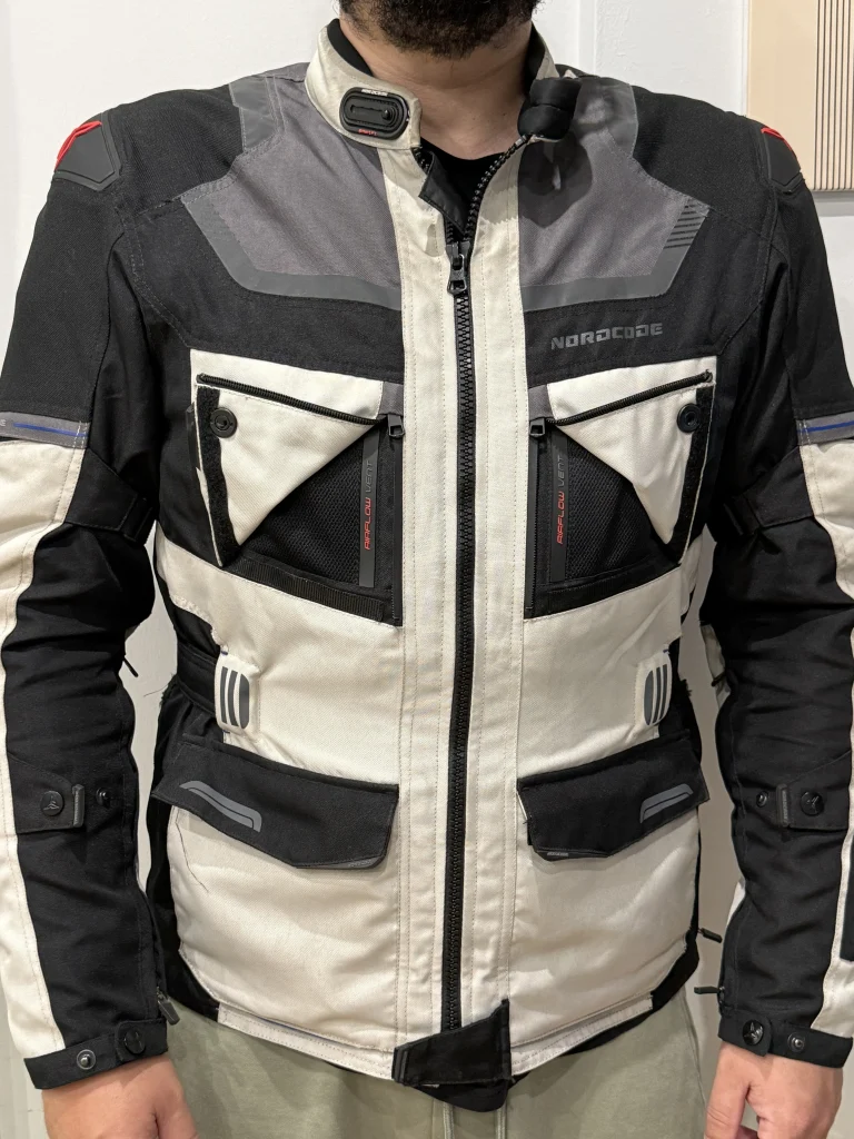 Μπροστινή όψη του μπουφάν Nordcode Evo 24 Adventure σε μέγεθος XL, με εμφανές το κεντρικό φερμουάρ, τις μπροστινές τσέπες, τα πάνελ στο στήθος και τη γραμμή εφαρμογής στο σώμα.
