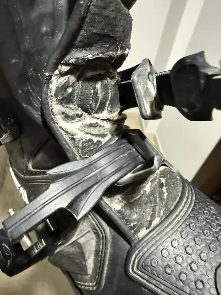 Κοντινή λεπτομέρεια φθοράς στη μπότα O’Neal Rider Pro Black μετά από 2 χρόνια χρήσης, με εμφανή σημάδια τριβής στο πλαϊνό προστατευτικό και στην περιοχή της αγκράφας.
