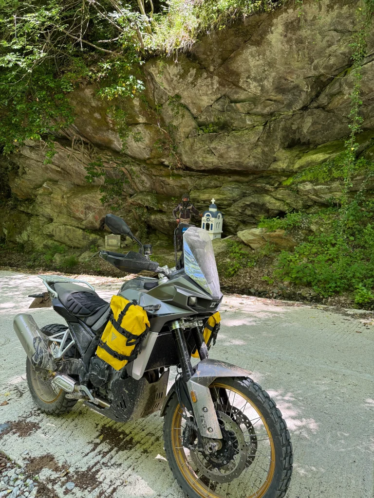 Adventure μοτοσυκλέτα σταματημένη δίπλα σε βραχώδες πέρασμα και μικρό παρεκκλήσι στον Όλυμπο